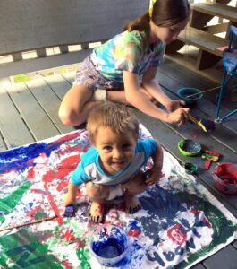 Young boy and sister finger painting